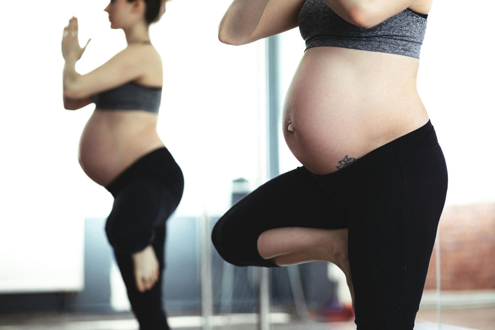 Femme enceinte qui fait du Yoga Femme enceinte qui fait du Yoga